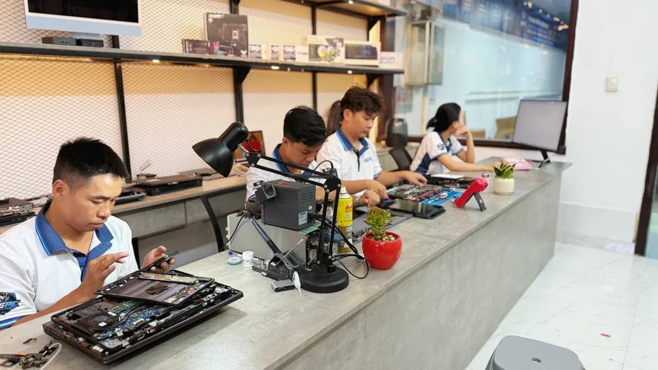 Kỹ thuật viên RIGPC tháo vỏ laptop trên bàn kỹ thuật tại showroom TP.HCM